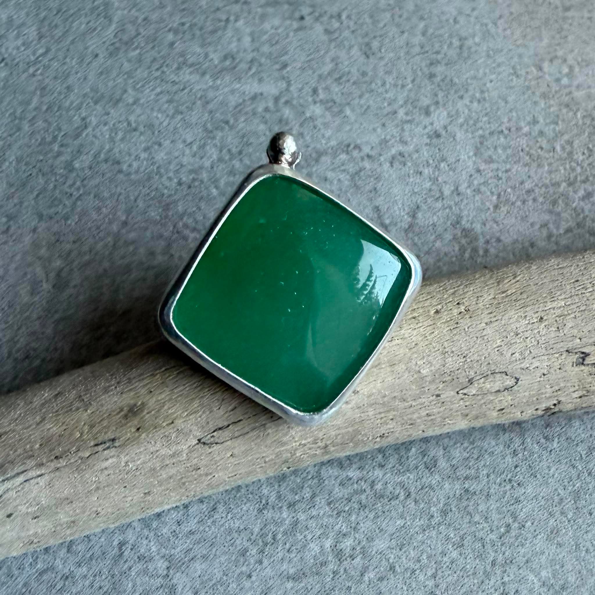 Kwadratowy pierścionek z zielonym awenturynem ze srebra 925 na dłoni. Zielony awenturyn kwadrat 22x22 mm gładki szlif ze srebrną kulką. Jasna polerowana kwadratowa oprawa i przyciemniana srebrna obrączka. Duży kwadratowy pierścionek z zielonym awenturynem regulowany Kwadratowy pierścionek z zielonym awenturynem ze srebra 925 na dłoni. Zielony awenturyn kwadrat 22x22 mm gładki szlif ze srebrną kulką. Jasna polerowana kwadratowa oprawa i przyciemniana srebrna obrączka. Duży kwadratowy pierścionek z zielonym awenturynem regulowany